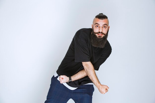 Uomo con la barba che balla o dà pose straordinarie.