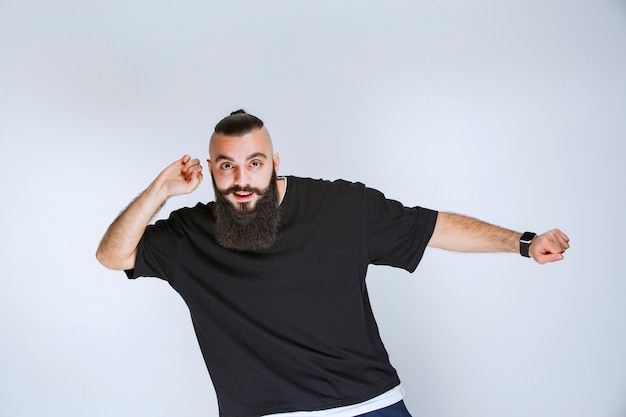 Uomo con la barba che balla o dà pose straordinarie.