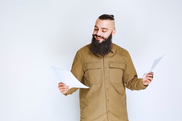 Uomo con la barba che controlla l'elenco dei progetti e segna note o correzioni.