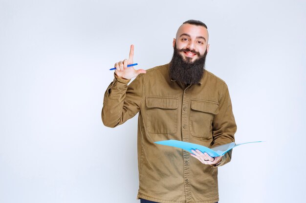 Uomo con la barba che controlla l'elenco dei progetti e segna note o correzioni.