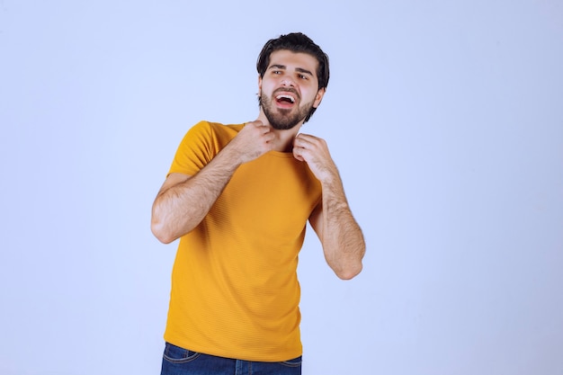 Uomo con la barba che mostra i muscoli del pugno e del braccio e si sente potente