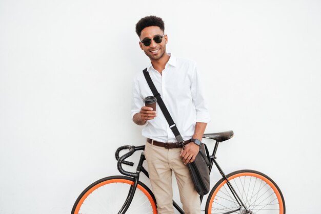 Uomo con la bicicletta che beve caffè.