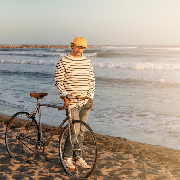 Uomo con la bicicletta in riva al mare