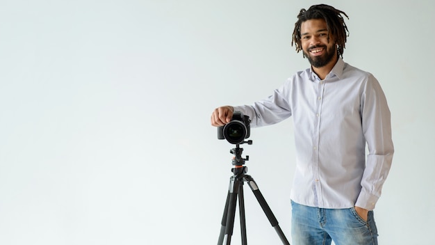 Uomo con la macchina fotografica e il fondo bianco