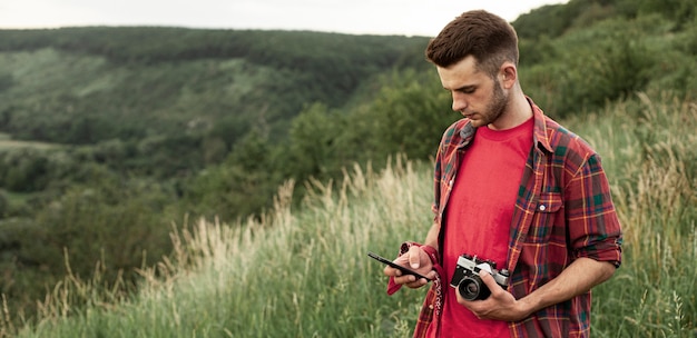 Uomo con la macchina fotografica in natura