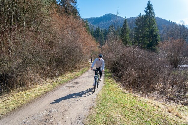 Uomo con la maschera sul viso in sella a una bicicletta durante la pandemia di Coronavirus / COVID-19.