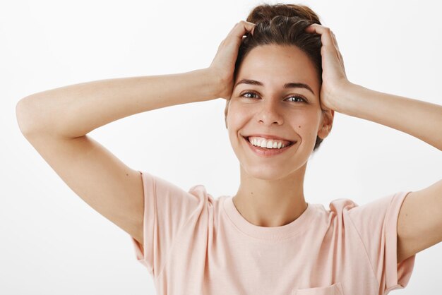 uomo con la pelle pulita pura che tocca la testa spensierata e sorride dolcemente ampiamente come sentirsi fresco ed energico dopo aver bevuto succo al mattino.