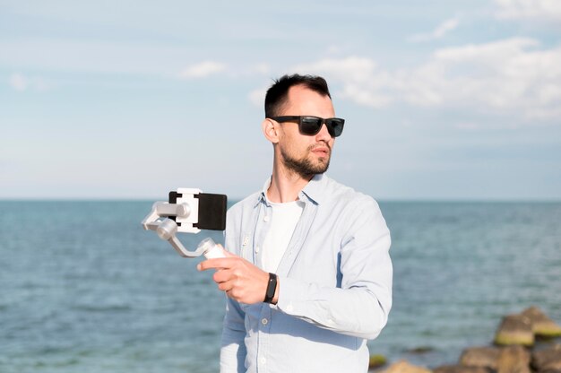 Uomo con lo smartphone in riva al mare