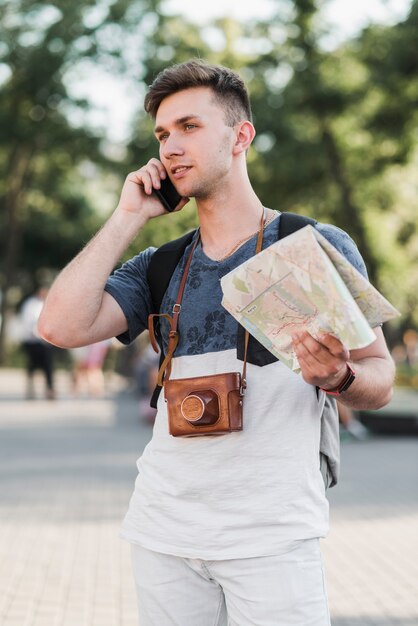 Uomo con mappa parlando al telefono