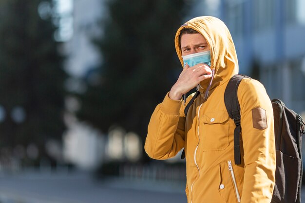 Uomo con maschera chirurgica all'aperto