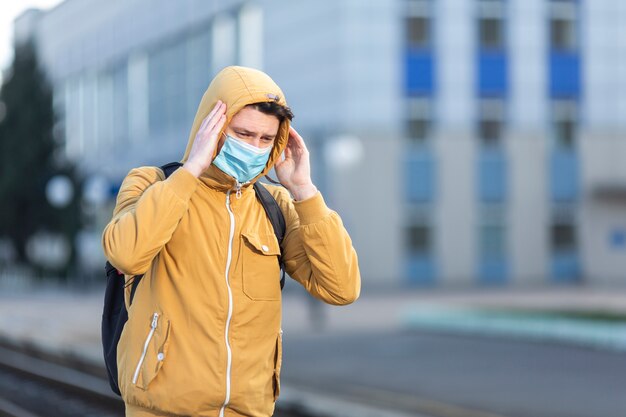 Uomo con maschera chirurgica all'aperto