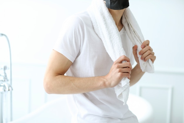 Uomo con maschera facciale nera, carbone purificante per la pelle. Concetto di bellezza