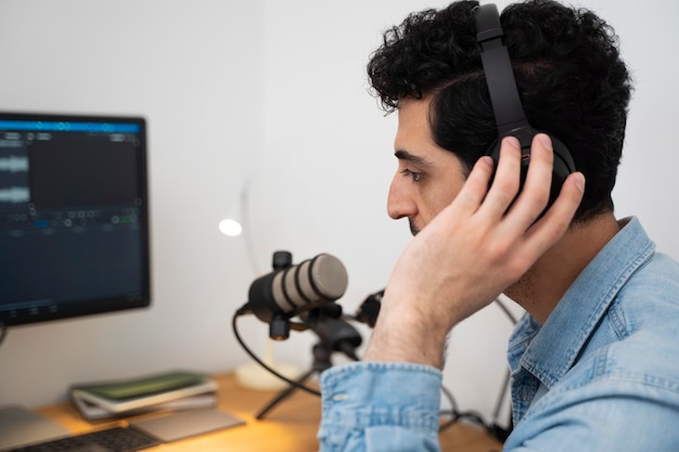 Uomo con microfono e cuffie che esegue un podcast in studio