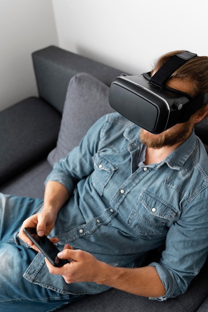 Uomo con occhiali vr tenendo il telefono