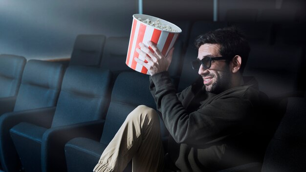 Uomo con popcorn al cinema