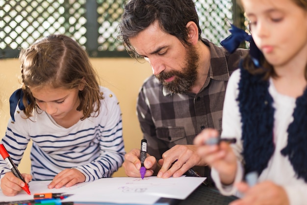 Uomo con ragazze che disegnano immagini