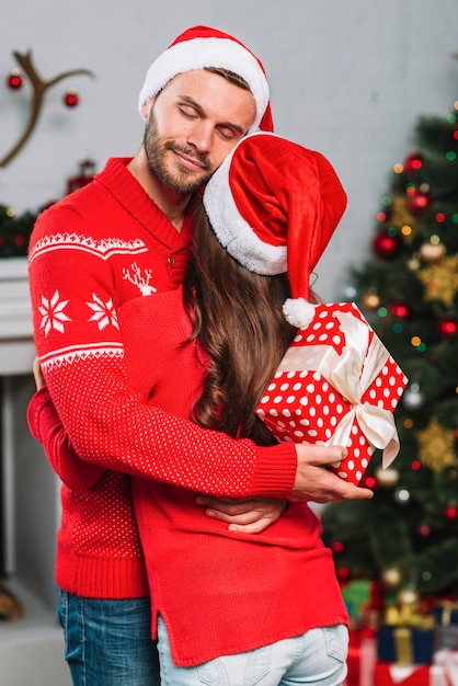 Uomo con regalo abbracciando la donna