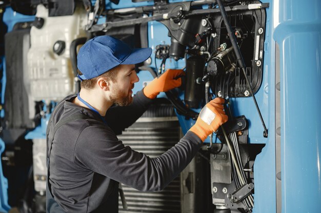 Uomo con strumenti per camion. Operaio in uniforme. Camion difettoso