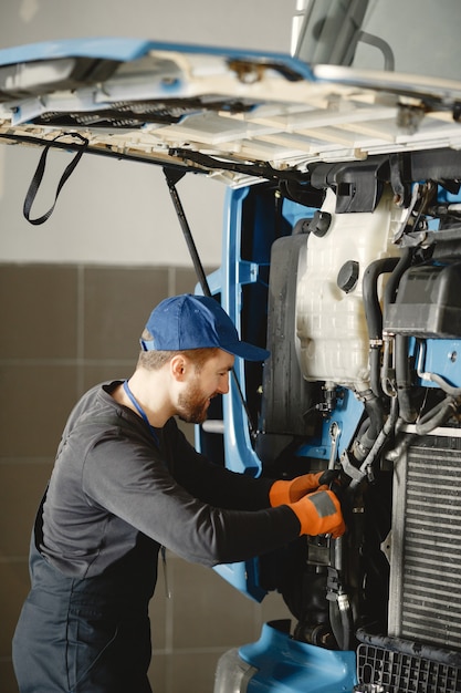 Uomo con strumenti per camion. Operaio in uniforme. Camion difettoso