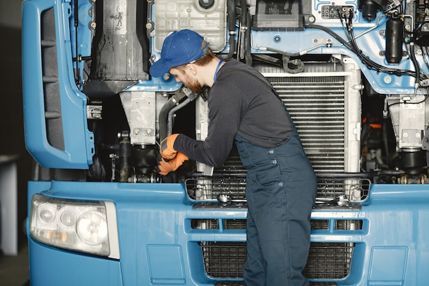 Uomo con strumenti per camion. Operaio in uniforme. Camion difettoso