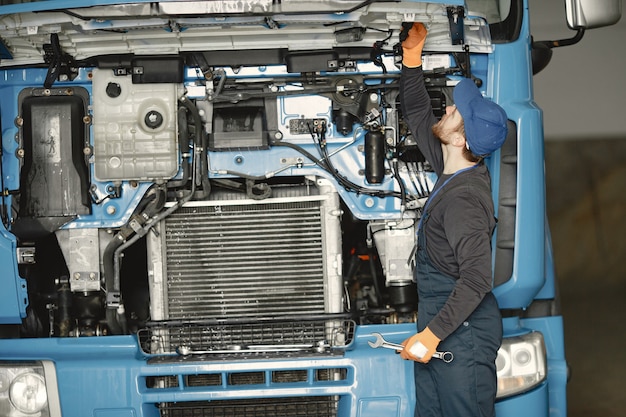 Uomo con strumenti per camion. Operaio in uniforme. Camion difettoso