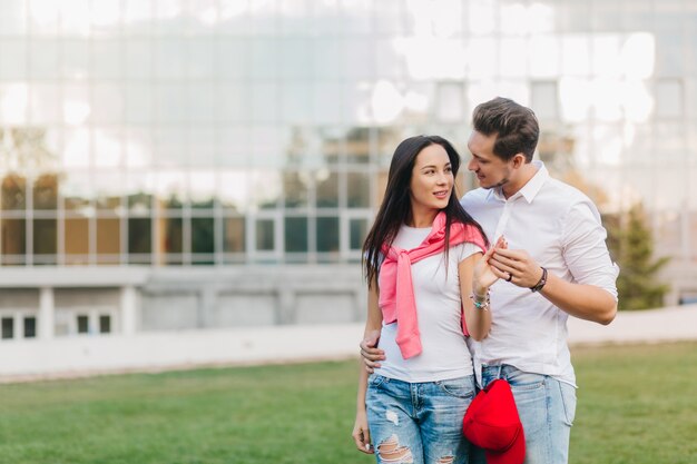 Uomo con taglio di capelli alla moda che tiene delicatamente la mano dell'amico