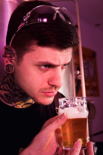 Uomo con tatuaggi che producono birra artigianale