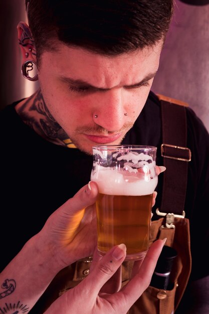 Uomo con tatuaggi che producono birra artigianale