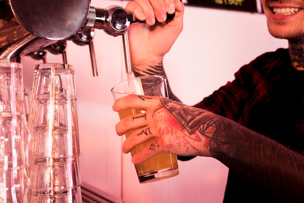 Uomo con tatuaggi che producono birra artigianale