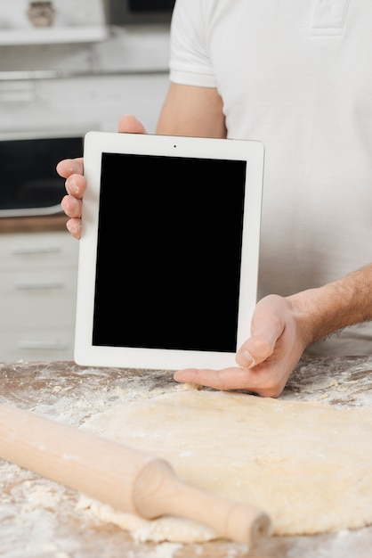 Uomo con tavoletta in cucina