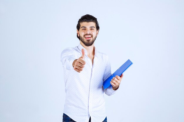 Uomo con una cartella blu che mostra il segno del divertimento