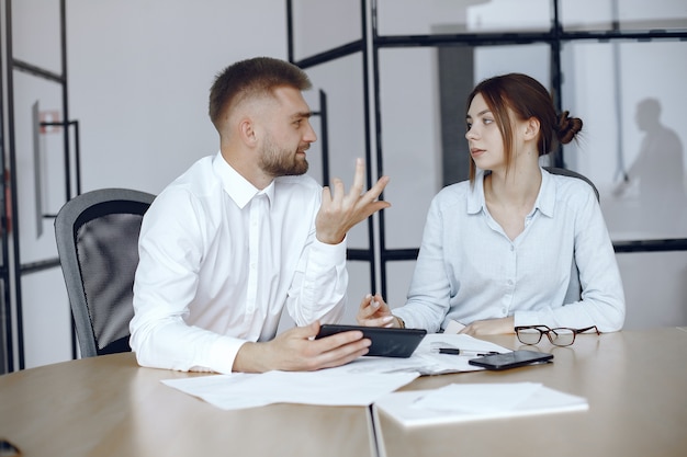 Uomo con una tavoletta. Partner commerciali a una riunione di lavoro Persone sedute al tavolo