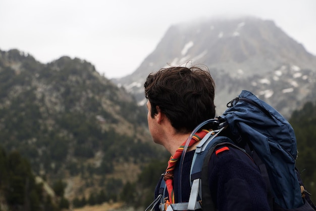 Uomo con uno zaino che fa un'escursione in montagna