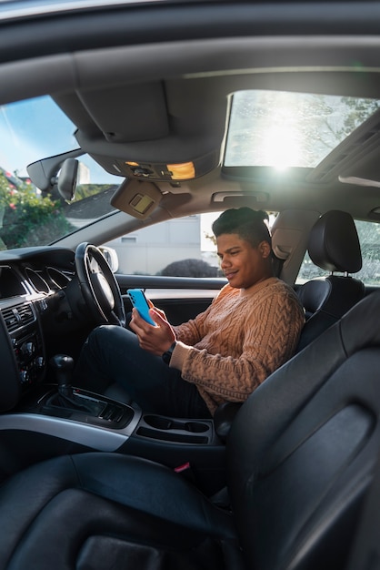 Uomo con vista laterale che utilizza lo smartphone in auto