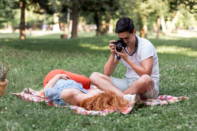 Uomo concentrato che prende le foto della sua ragazza