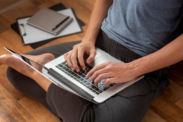 Uomo confortevole utilizzando laptop a casa in quarantena al lavoro