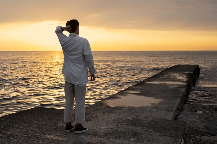 Foto gratuito uomo contemplativo a figura intera in riva al mare