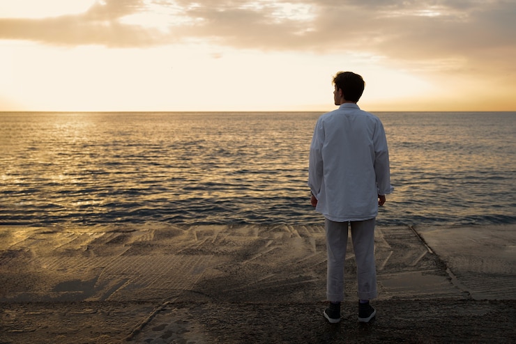 Foto gratuito uomo contemplativo a figura intera in riva al mare
