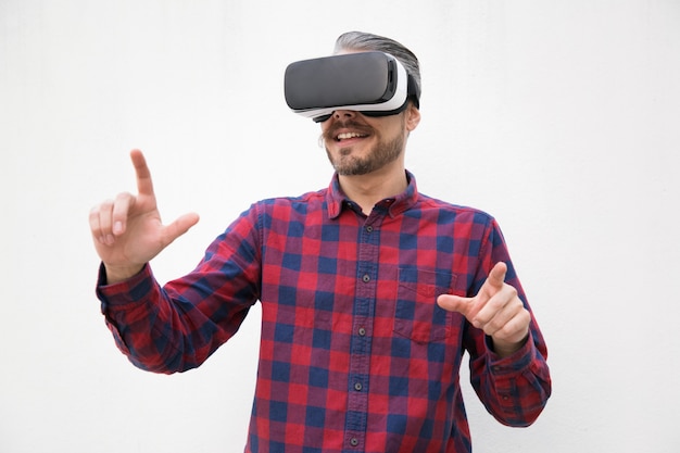 Uomo contento che usando le cuffie da realtà virtuale