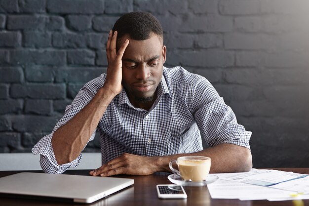 Uomo d'affari africano infelice che si sente stressato e frustrato