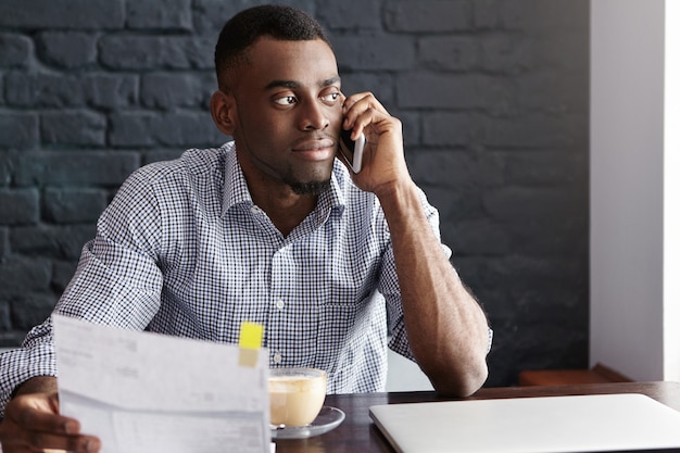 Uomo d'affari afroamericano sicuro bello che fa lavoro di ufficio