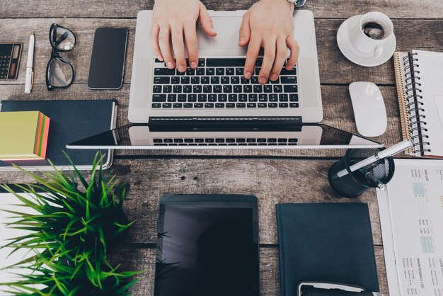 Uomo d'affari al lavoro vista dall'alto del primo piano dell'uomo che lavora al computer portatile