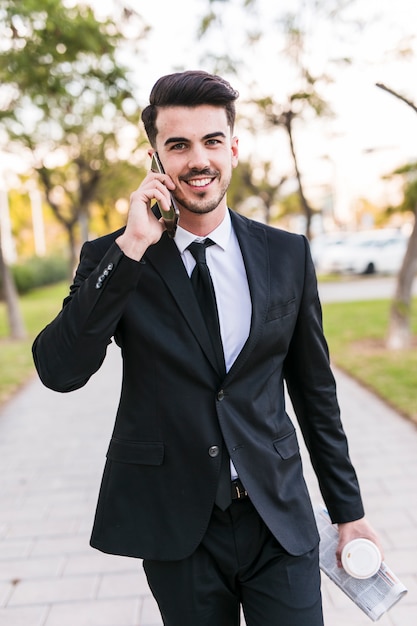 Uomo d&#39;affari al telefono al parco