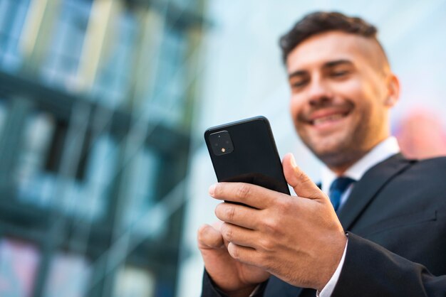 Uomo d'affari all'aperto usando la vista bassa del telefono