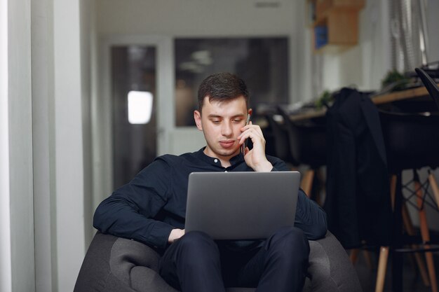 Uomo d'affari alla moda che lavora in un ufficio e utilizzare il computer portatile