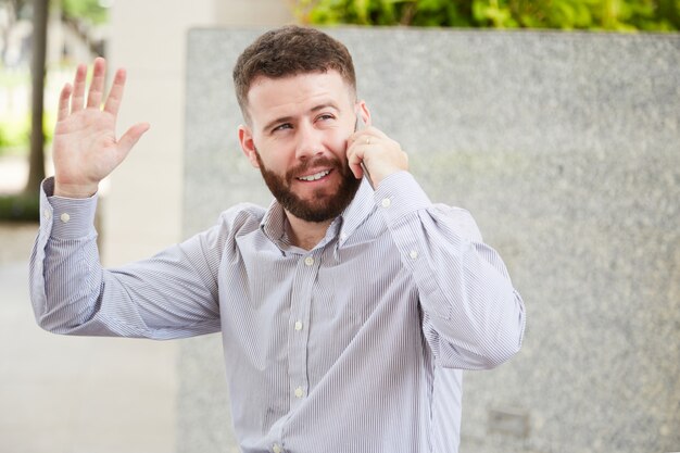 Uomo d'affari amichevole che parla sul telefono