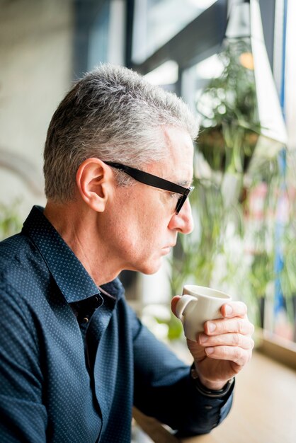 Uomo d&#39;affari anziano che si alza di caffè