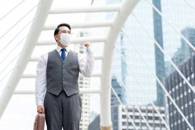 Uomo d'affari asiatico ritratto indossando maschera protettiva per la protezione durante la quarantena