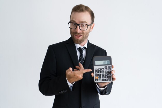 Uomo d'affari barbuto intraprendente che indica al calcolatore