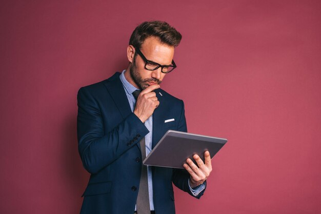 Uomo d'affari bello che lavora in un tablet